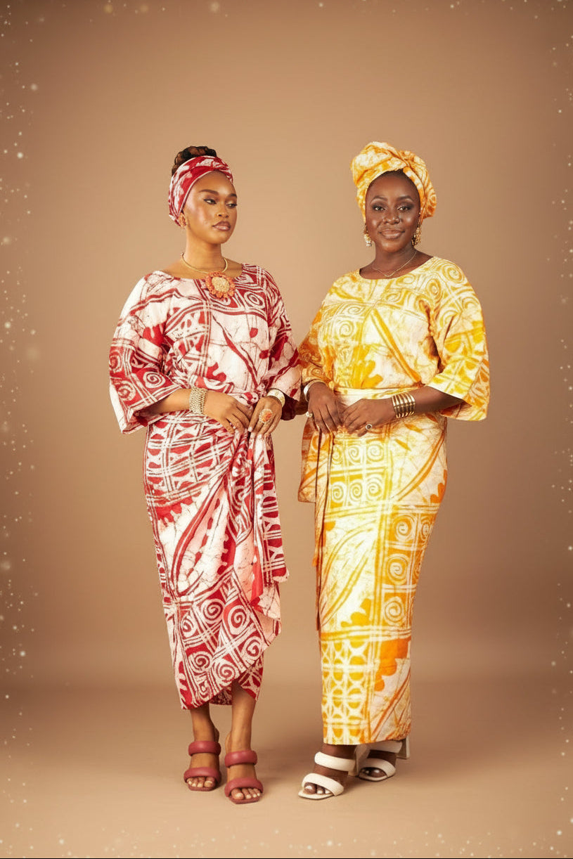 Two women in traditional attire standing against a dark background